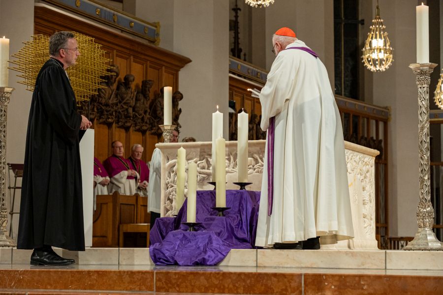 Landesbischof Christian Kopp und Kardinal Reinhard Marx entzünden Kerzen beim Trauergottesdienst in der Frauenkirche zum Gedenken an die Anschlagsopfer