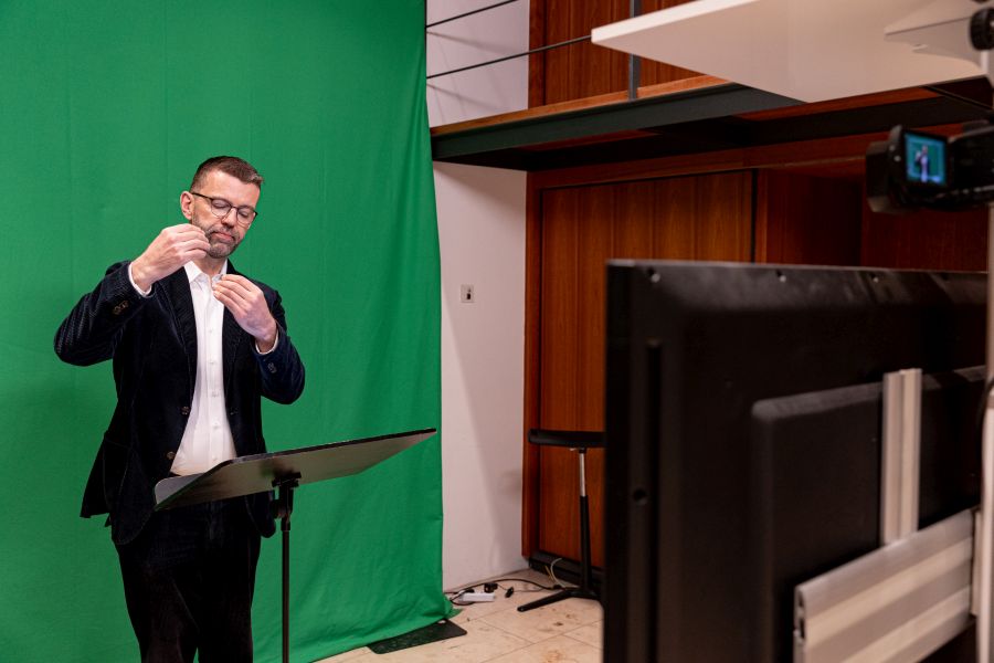 Gebärdensprachdolmetscher Winfried Locher vor der Green Screen im Gemeindesaal des Doms