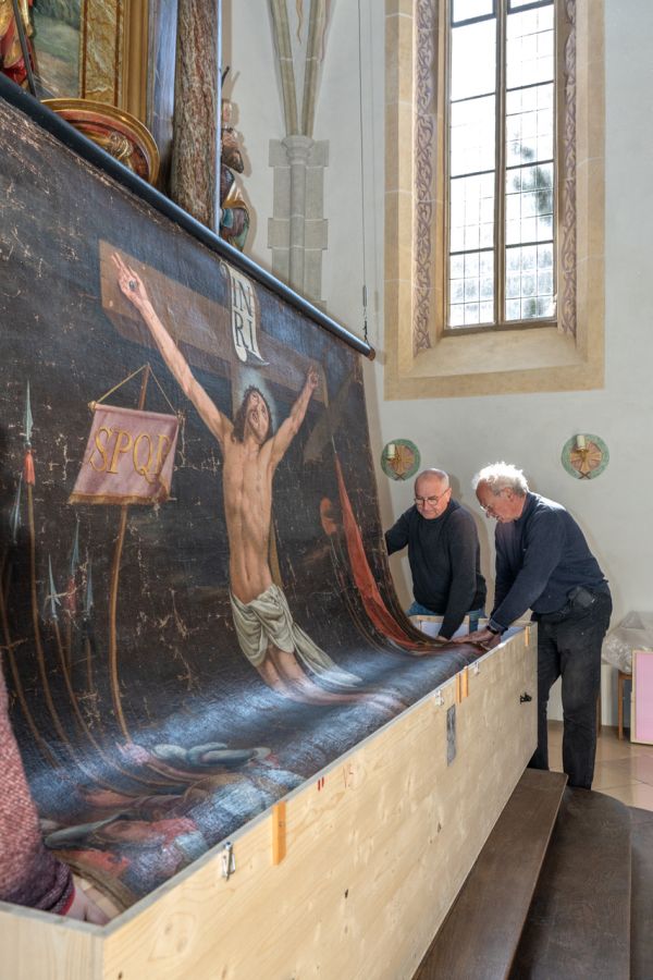 Das restaurierte Fastentuch wird in  St. Johann Baptist in Oberwarngau vor dem Altar aufgehängt.