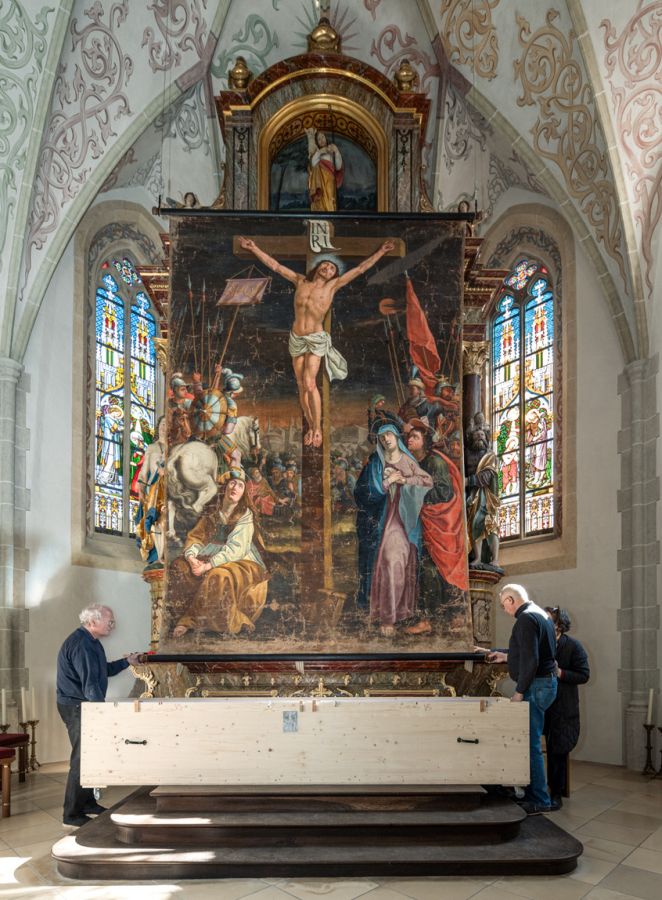 Das restaurierte Fastentuch wird in  St. Johann Baptist in Oberwarngau vor dem Altar aufgehängt.