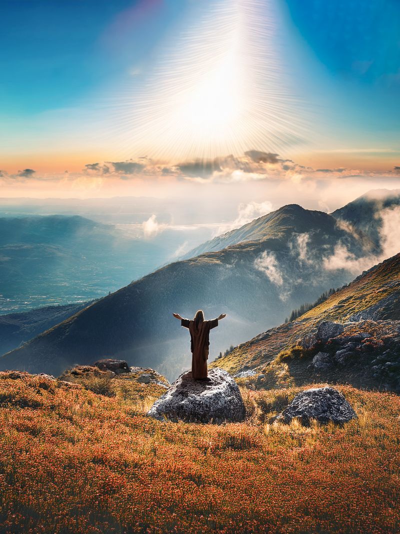 Christusfigur mit ausgebreiteten Armen auf einem Berg. Der Himmel darüber ist erfüllt von hellem, gleißenden Licht.