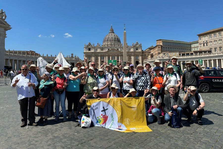 Gruppe von gehörlosen Pilgerinnen und Pilgern auf dem sonnigen Petersplatz in Rom