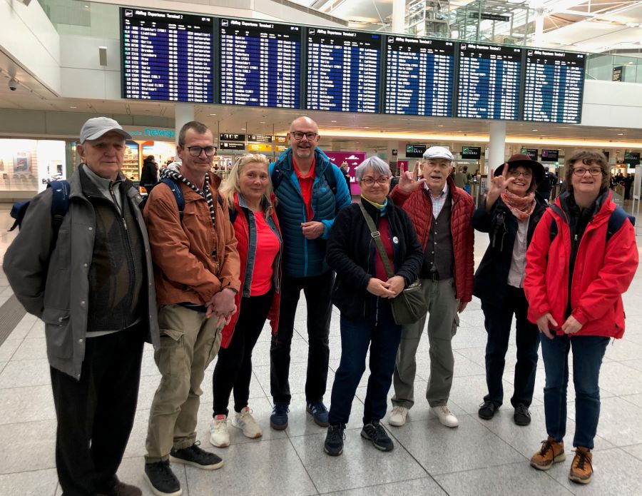 Die Gruppe Gehörloser vor der Flugtafel auf dem Münchner Flughafen