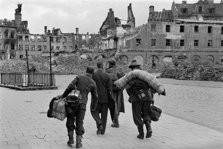 Kriegsheimkehrer im Juli 1945 vor Ruinen in München