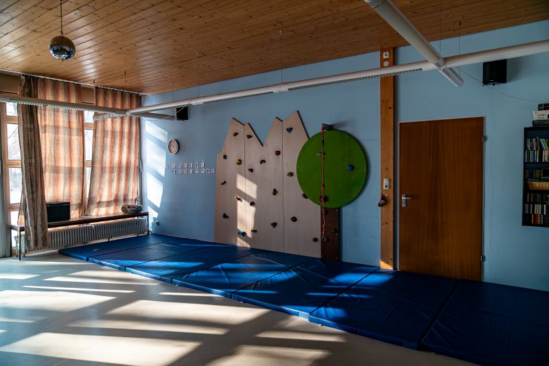 Turnsaal mit blauen Matten und Kletterwand in der Kita St. Markus