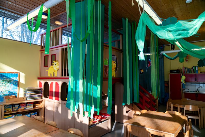 Gruppenraum mit Spielturm, dekoriert mit grünen Girlanden in der Kita St. Markus