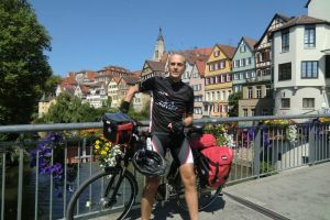 Frank Herrmann mit seinem bepackten Fahrrad auf einer Brücke
