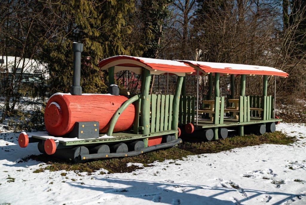 Holzzug (Dampflokomotive mit Waggon) im verschneiten Garten des Kinderhauses Maria Schutz