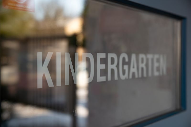 Gläsernes Schild am Eingang mit der Aufschrift "Kindergarten".