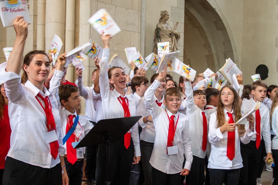 Kinder- und Jugendchor der Pueri Cantores jubeln und wedeln mit ihren Notenheften