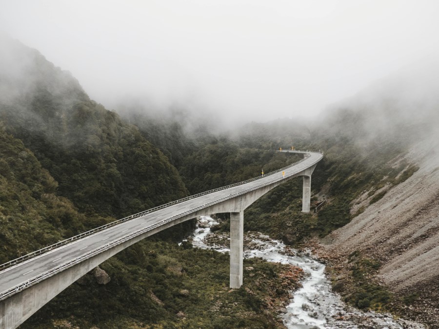 Brücke über Gebirgsfluss im Nebel