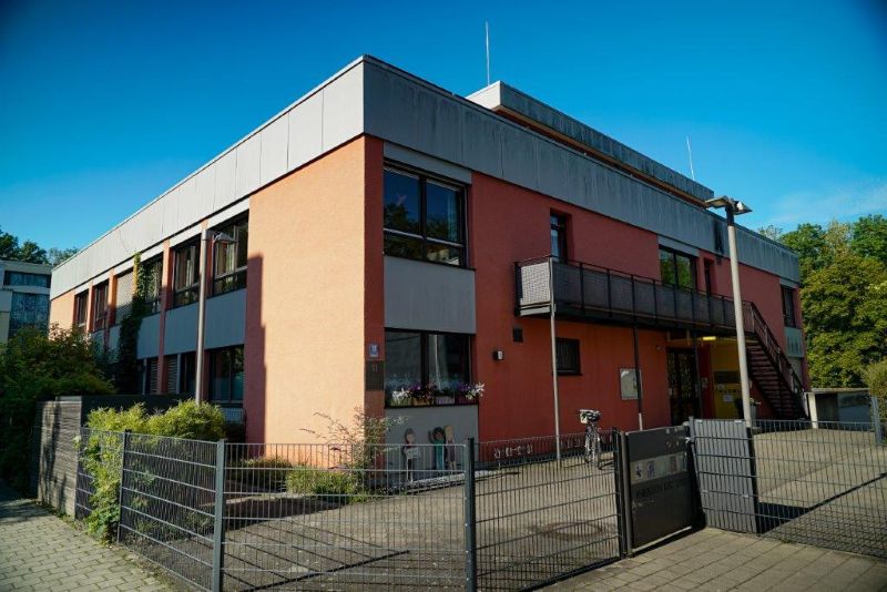 Die Kita Maria Schutz von außen, ein rotes, einstöckiges Flachdachgebäude