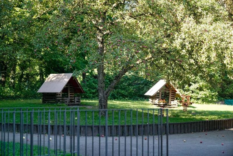 Zwei Holzhäuschen im grünen Garten der Kita Maria Schutz