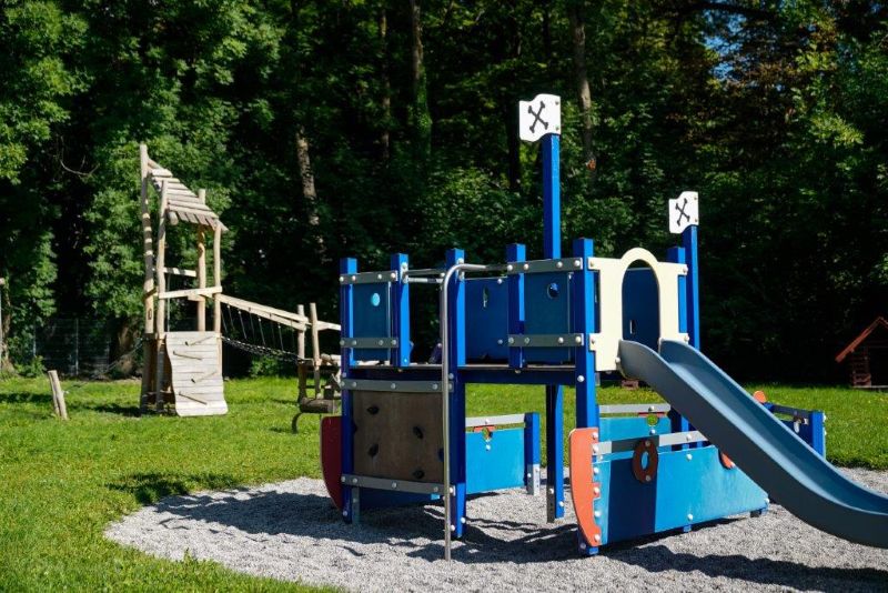 Blaues Klettergerüst in Form eines Piratenschiffes mit Rutsche im Garten der Kita Maria Schutz