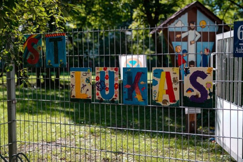 Buntes Schild am Zaun der Kita mit der Aufschrift "St. Lukas"