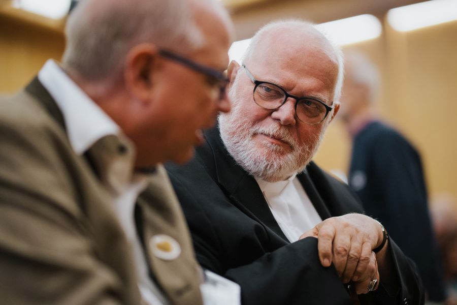 Kardinal Reinhard Marx hört beim Tag der Begegnung für Missbrauchsopfer am 20. September 2025 in Rottach-Egern Pfarrer Kilian Semel zu