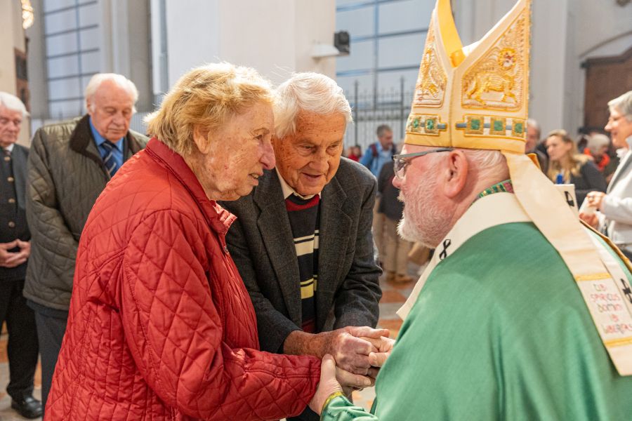 Kardinal Reinhard Marx im Gespräch mit einem Ehepaar bei der Festmesse der Ehejubilare am 12. Oktober 2025 im Münchner Liebfrauendom