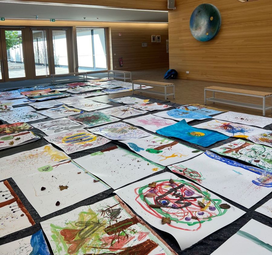 Fertige Bilder der Schüler liegen in der Aula der Pater-Rupert-Mayer-Volksschule