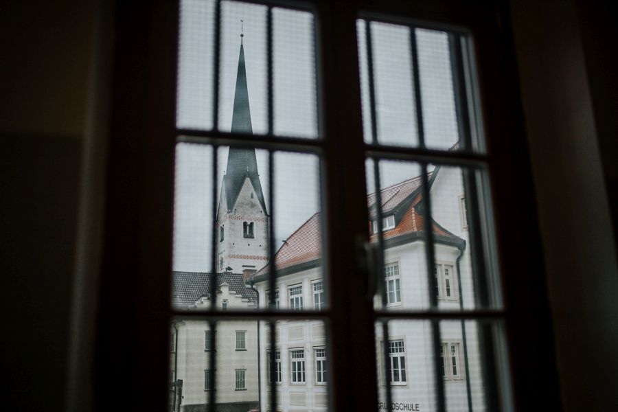 Blick aus einem vergitterten Fenster der Justizvollzugsanstalt Garmisch-Partenkirchen auf eine Kirche
