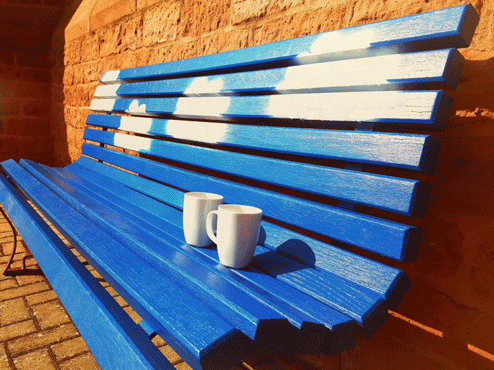 Blaue Bank mit zwei Tassen