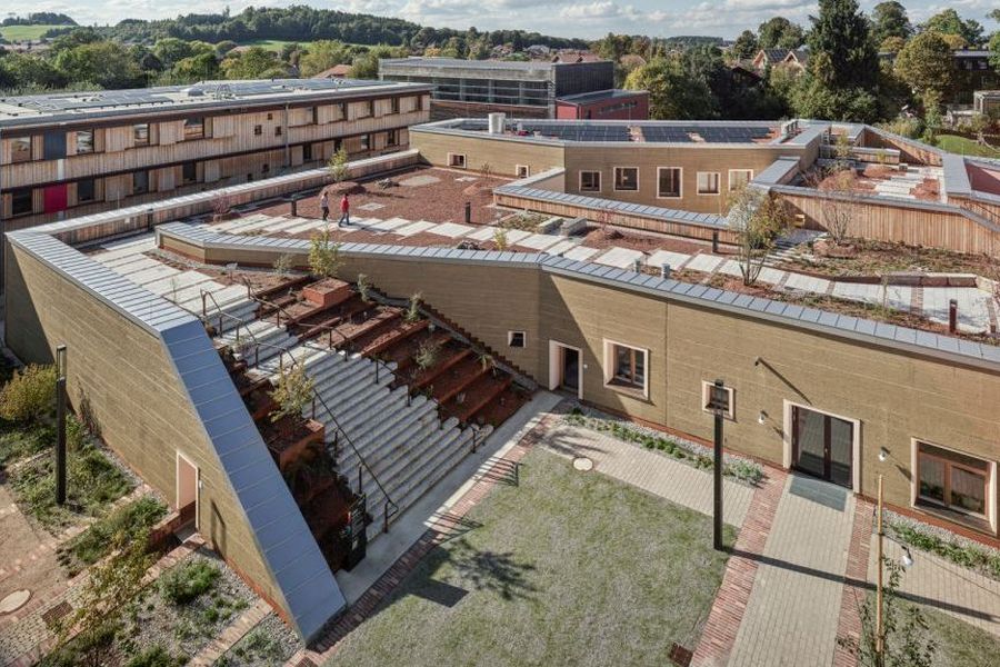 Drohnenaufnahme des Lehmbaus mit Dachterrasse auf dem Campus Traunstein