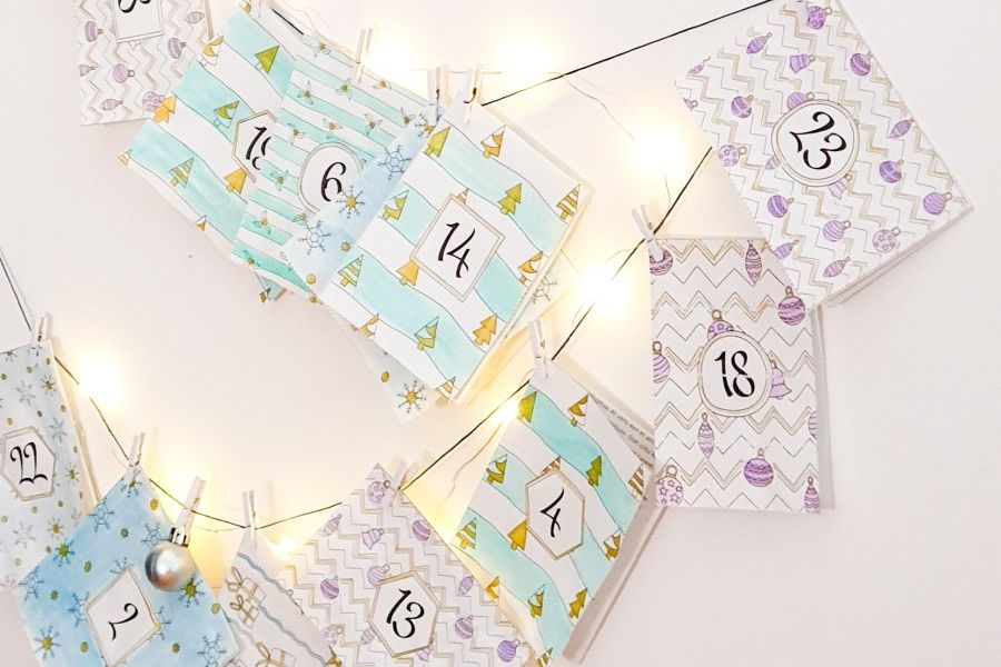 Adventskalender aus Papieren an einer Lichterkette