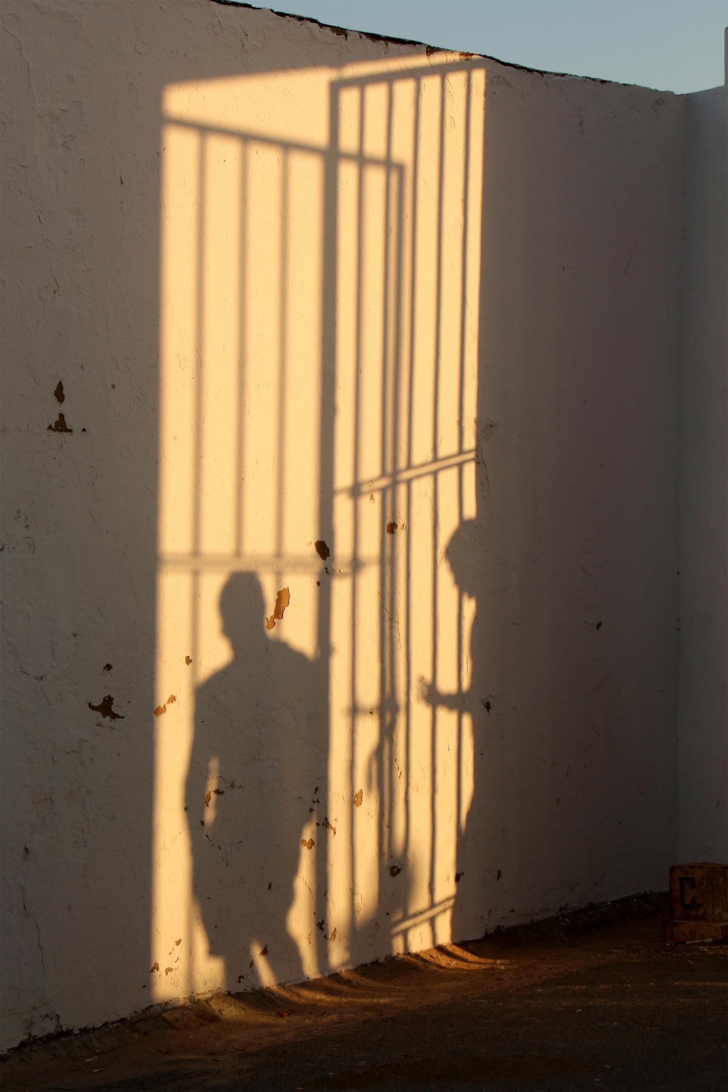 Schatten von Gittern und Menschen