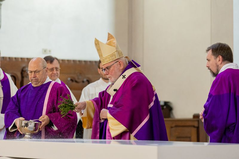 Kardinal Marx besprengt den neuen Altar mit Weihwasser