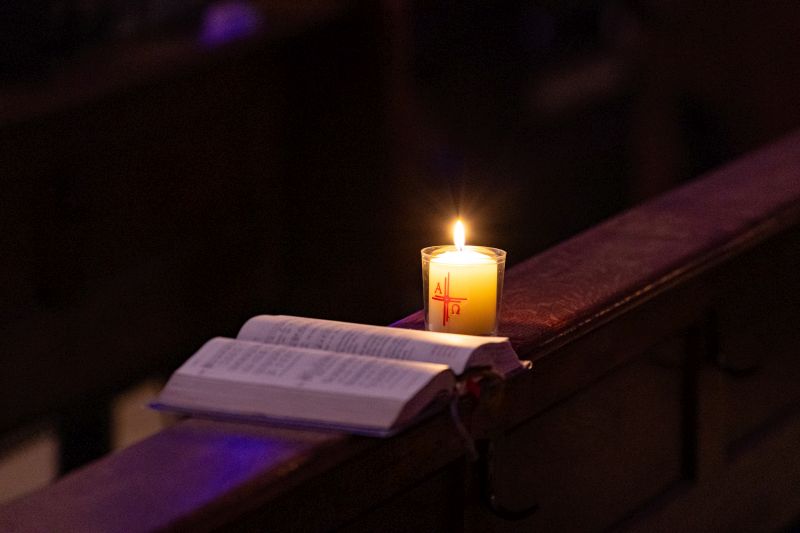 Ein Gotteslob neben einer brennenden Kerze