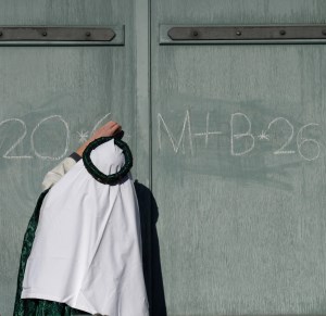 Sternsinger schreibt mit Kreide CMB an das Portal der Pfarrkirche